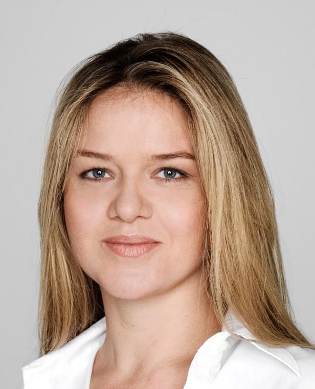 Porträt einer Frau mit blonden Haaren und blau-grauen Augen.