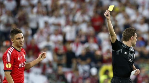 Ein Schiedsrichter zeigt einem Fußballspieler die gelbe Karte.