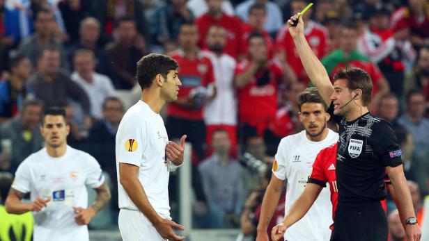 Ein Schiedsrichter zeigt einem Fußballspieler die gelbe Karte.