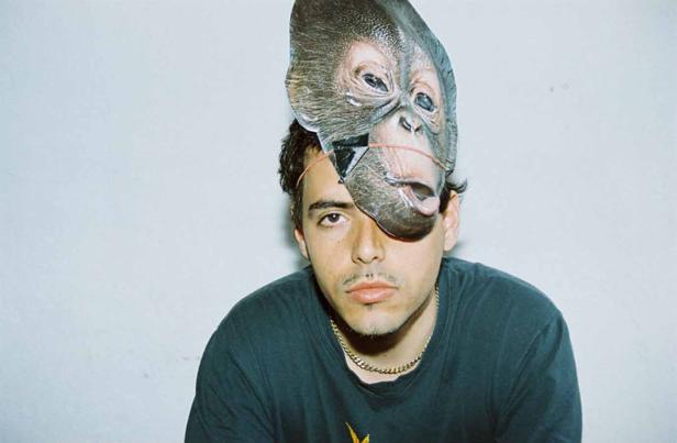 Ein Mann trägt eine Affenmaske, die mit einem Gummiband befestigt ist.