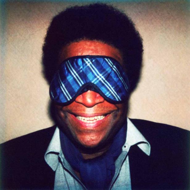 Ein Mann mit Schlafmaske lächelt in die Kamera.