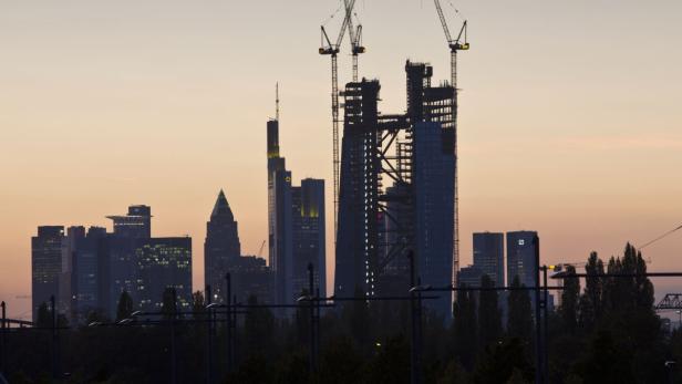 Die Skyline von Frankfurt am Main bei Sonnenuntergang mit einem Gebäude im Bau.