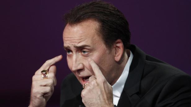 Nicolas Cage gestikuliert mit den Fingern vor seinem Gesicht.