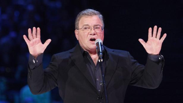 William Shatner gestikuliert mit beiden Händen während einer Rede.