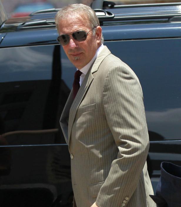 Kevin Costner trägt einen Anzug und eine Sonnenbrille.