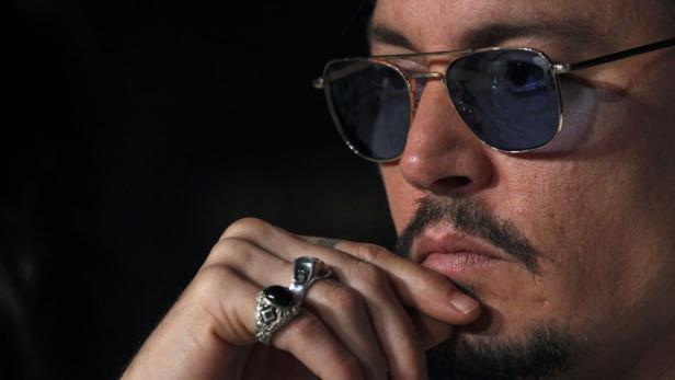 Nahaufnahme von Johnny Depp mit Sonnenbrille und auffälligen Ringen.