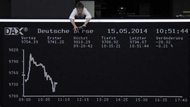 Ein Mann justiert eine Kamera vor einer Anzeigetafel der Deutschen Börse am 15.05.2014.