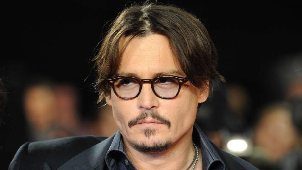 Johnny Depp mit Brille und Bart bei einer Veranstaltung.