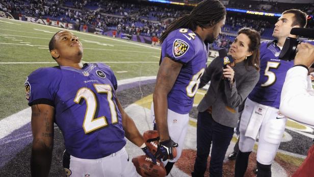 Ein Footballspieler der Baltimore Ravens wird von einer Reporterin interviewt.
