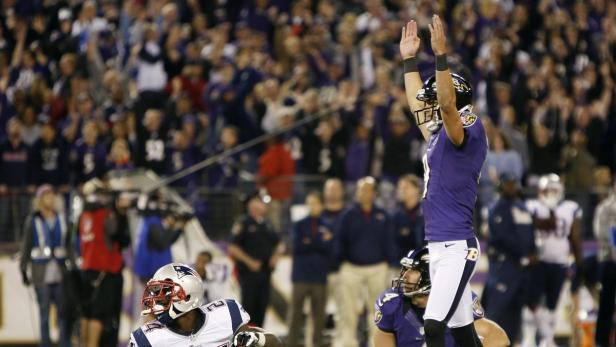 Ein Footballspieler der Baltimore Ravens jubelt mit erhobenen Armen vor einer jubelnden Menge.