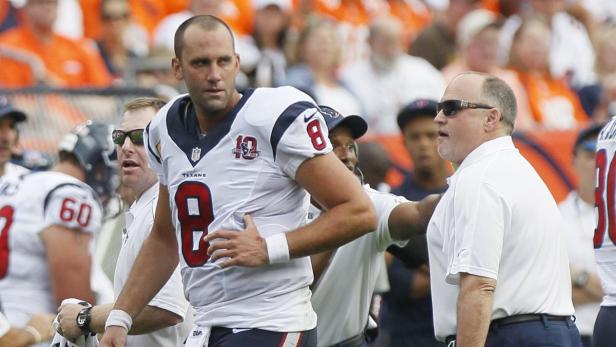 Ein Footballspieler der Houston Texans wird von einem Trainer betreut.