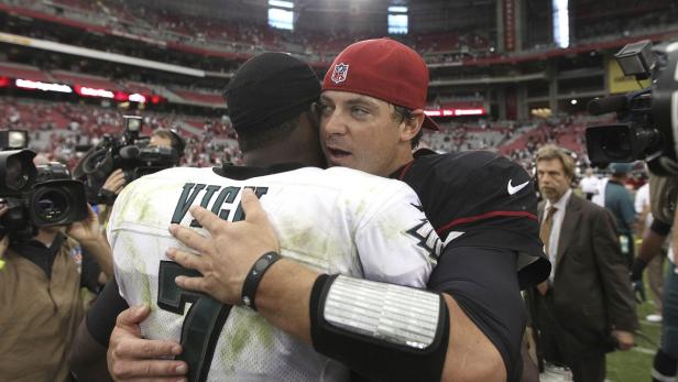Zwei Footballspieler umarmen sich auf dem Spielfeld.