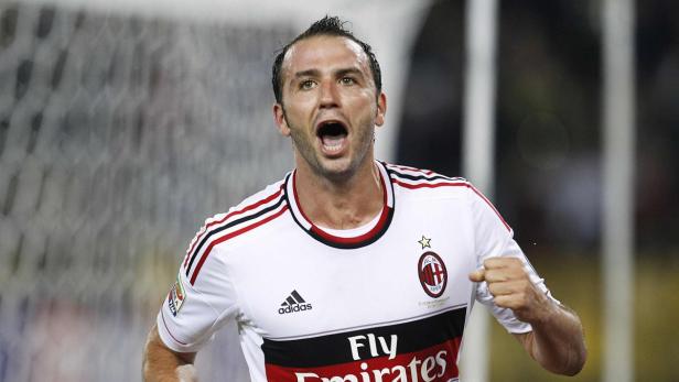 Ein Fußballspieler im Trikot von AC Mailand jubelt mit geballter Faust.