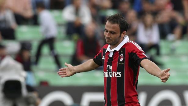 Ein Fußballspieler im rot-schwarzen Trikot gestikuliert auf dem Spielfeld.