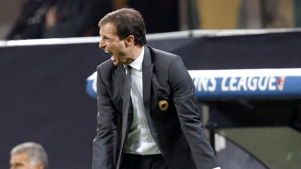 Ein Fußballtrainer gestikuliert aufgeregt am Spielfeldrand.