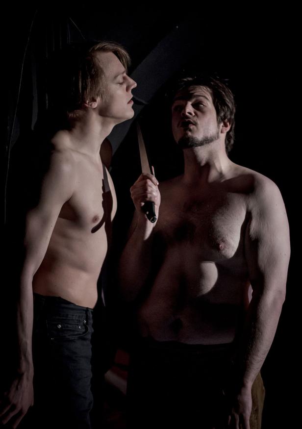 Ein Mann bedroht einen anderen Mann mit einem Messer.