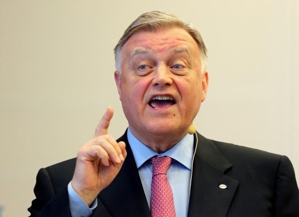 Ein Mann im Anzug gestikuliert mit erhobenem Zeigefinger.