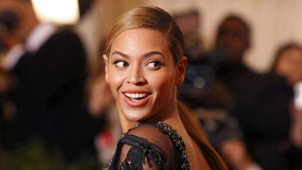 Beyoncé lächelt und blickt über ihre Schulter.