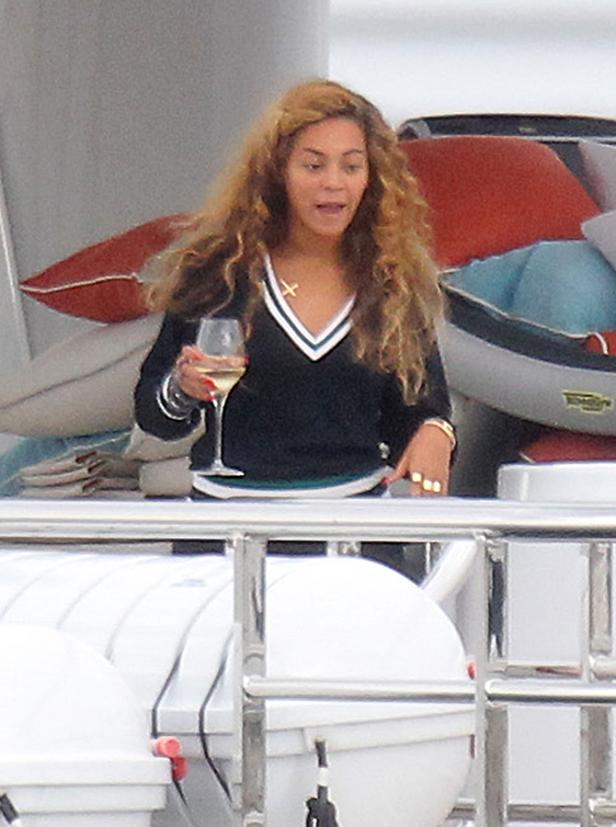 Beyoncé hält ein Glas Wein auf einer Yacht.