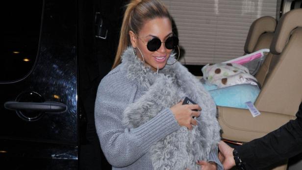Beyoncé verlässt ein Auto mit einer grauen Stola und runden Sonnenbrillen.