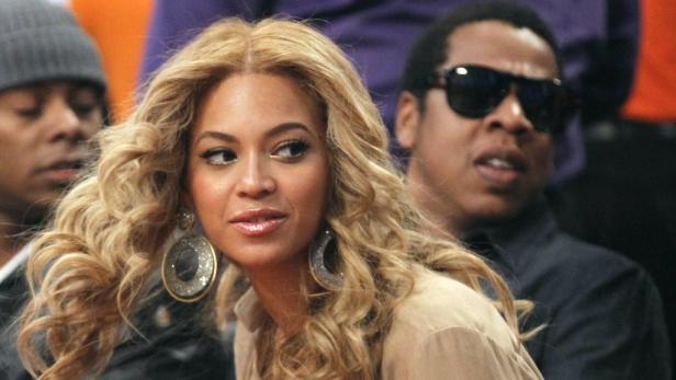Beyoncé mit großen Ohrringen, zusammen mit Jay-Z im Publikum.