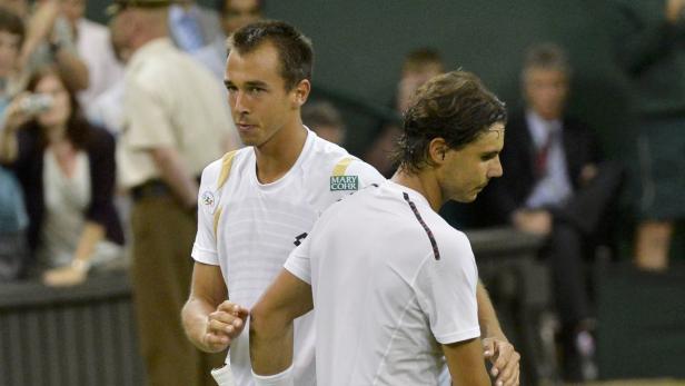 Zwei Tennisspieler in weißen Trikots stehen auf dem Platz.
