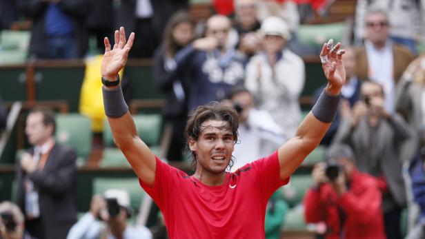 Rafael Nadal feiert mit erhobenen Armen einen Sieg auf dem Tennisplatz.