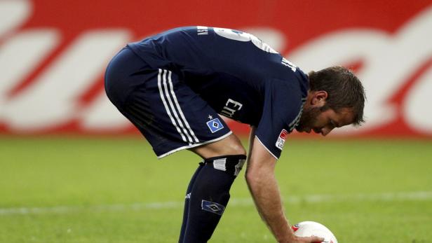 Ein Fußballspieler des Hamburger SV beugt sich über einen Ball.