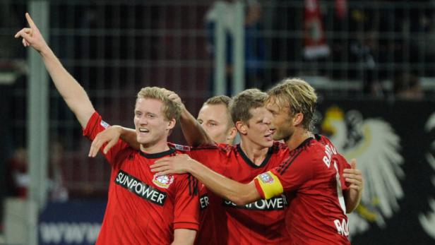 Mehrere Fußballspieler in roten Trikots feiern gemeinsam ein Tor.