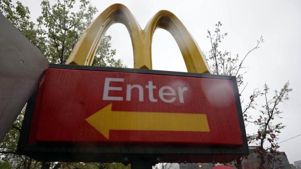 Ein Schild mit der Aufschrift „Enter“ und einem Pfeil unter den goldenen Bögen von McDonald's.