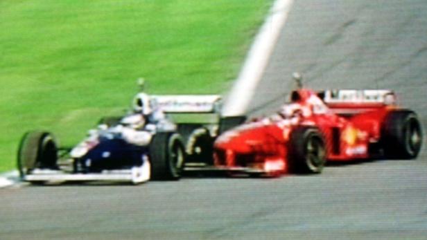 Ein blauer und ein roter Formel-1-Rennwagen fahren auf einer Rennstrecke.