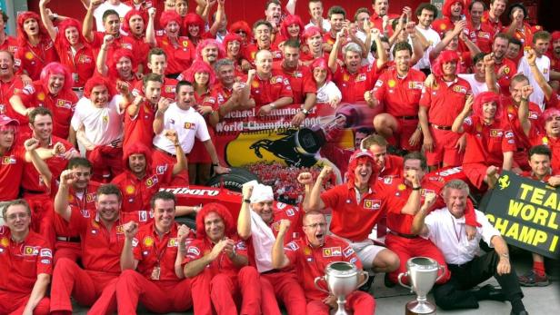 Das Ferrari-Team feiert den Gewinn der Formel-1-Weltmeisterschaft, viele tragen rote Perücken.