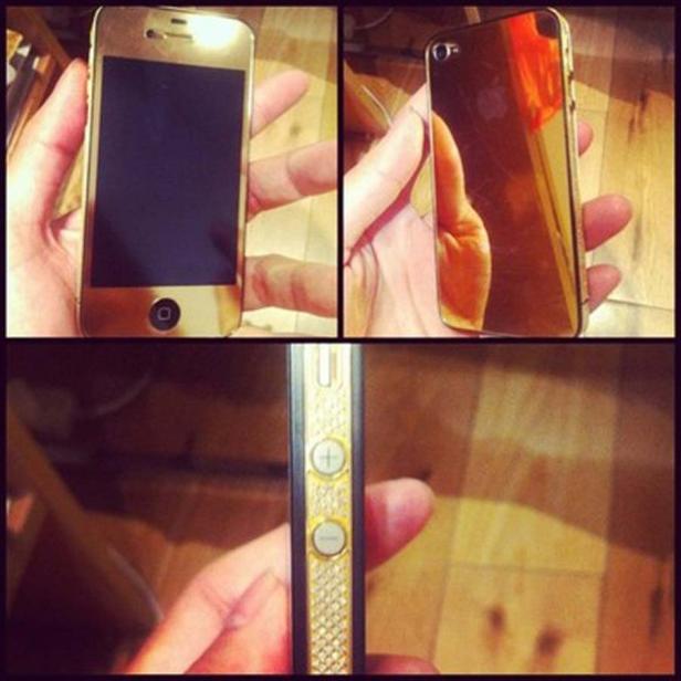 Nahaufnahme eines goldenen iPhones, das in der Hand gehalten wird.