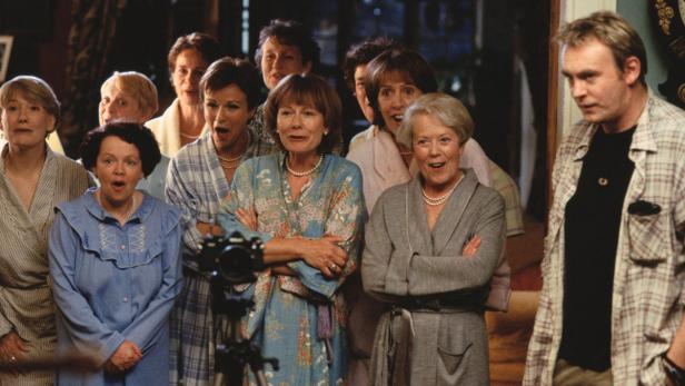 Eine Gruppe von Frauen mittleren Alters posiert überrascht für ein Foto.