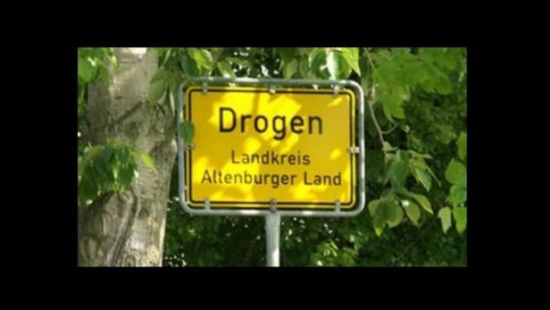 Ein gelbes Ortsschild von Drogen, Landkreis Altenburger Land.