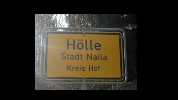 Ein gelbes Ortsschild von „Hölle“, Stadt Naila, Kreis Hof.