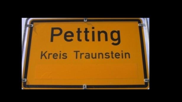 Ein gelbes Ortsschild von Petting im Landkreis Traunstein.