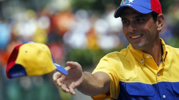 Ein lächelnder Mann wirft eine venezolanische Baseballkappe in die Luft.