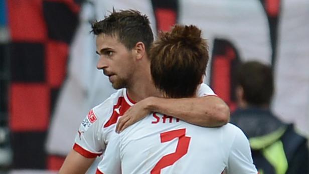 Zwei Fußballspieler umarmen sich auf dem Spielfeld.