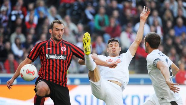 Zwei Fußballspieler kämpfen um den Ball während eines Spiels.