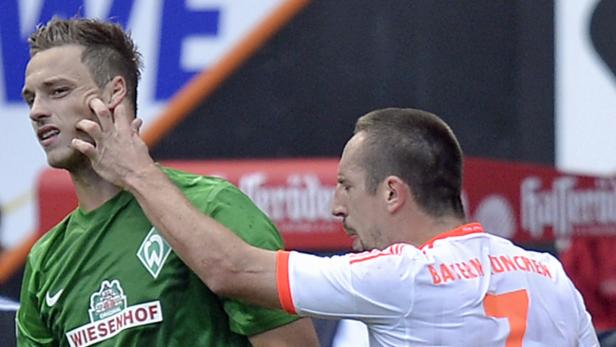 Ein Fußballspieler berührt das Gesicht eines anderen Spielers während eines Spiels.