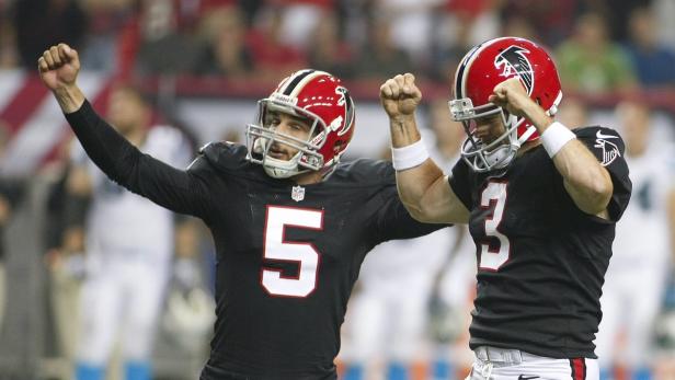 Zwei Footballspieler der Atlanta Falcons jubeln mit erhobenen Fäusten.