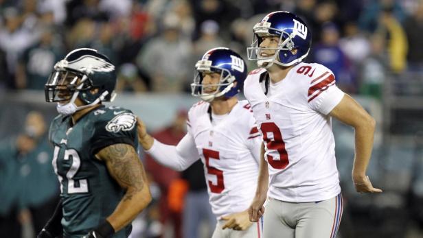 Drei Footballspieler der New York Giants und Philadelphia Eagles stehen auf dem Feld.