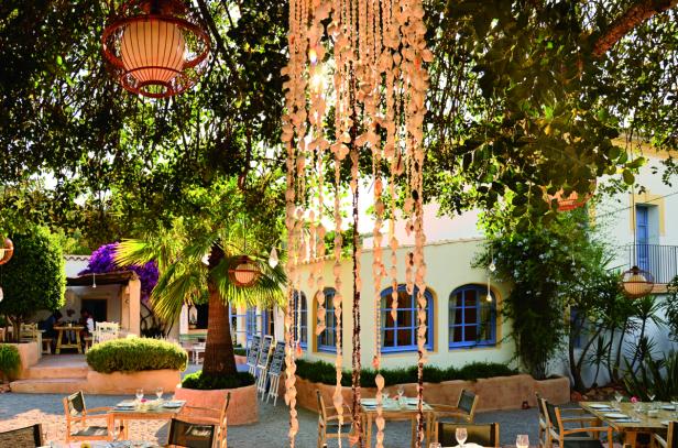 Das Restaurant „Cicale“ befindet sich in der Stadt San Lorenzo. Ein Restaurant im Freien mit Tischen, Stühlen und Dekorationen aus Muscheln und Laternen.