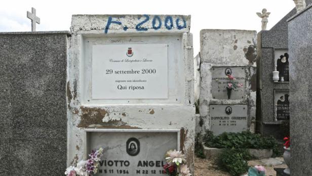 Ein Friedhof mit mehreren Grabsteinen, darunter einer für einen unbekannten Migranten vom 29. September 2000.