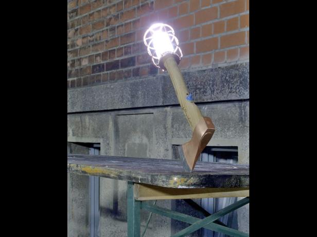 Eine Axt mit einem leuchtenden Lampenkopf steht auf einem Tisch.