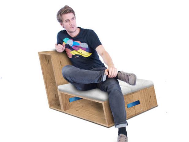 Ein Mann sitzt entspannt auf einem modernen Holzstuhl mit weißem Kissen.