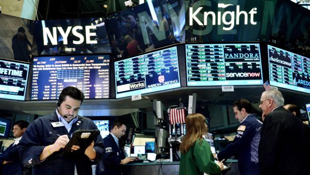Händler arbeiten an der New Yorker Börse (NYSE) vor Anzeigetafeln mit Aktienkursen.