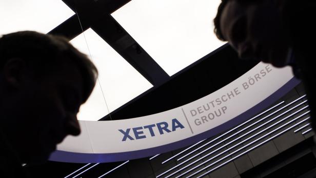 Das Logo der Deutschen Börse Xetra mit zwei Personen im Vordergrund.