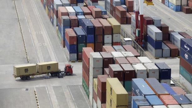Ein Lastwagen transportiert Container in einem Containerhafen.